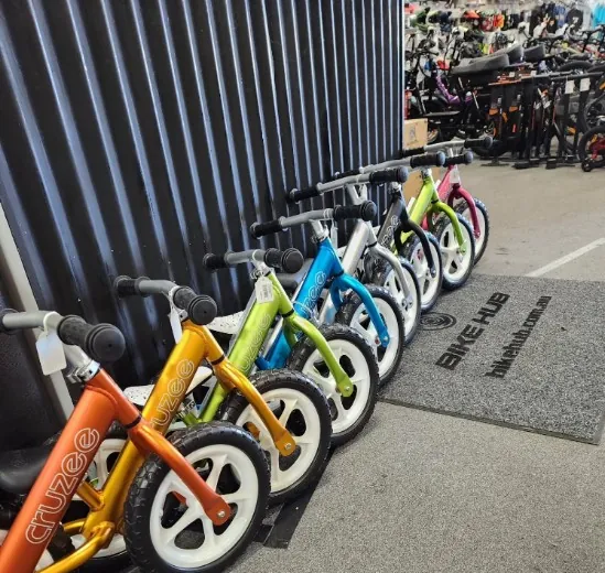 A row of colourful Cruzee balance bikes in the shop