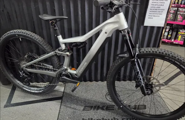 A silver Focus electric mountain bike on the Bike Hub floor mat