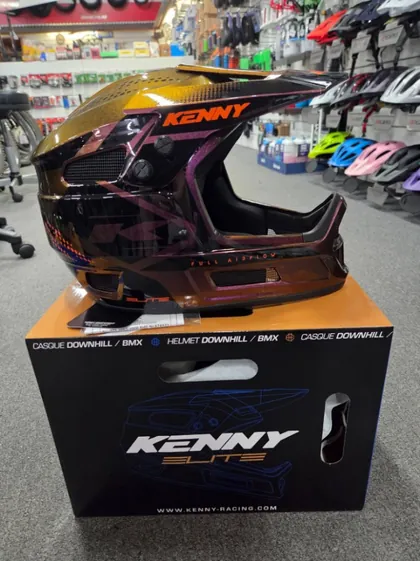A Kenny Elite full-face helmet in a gold chameleon finish on its box