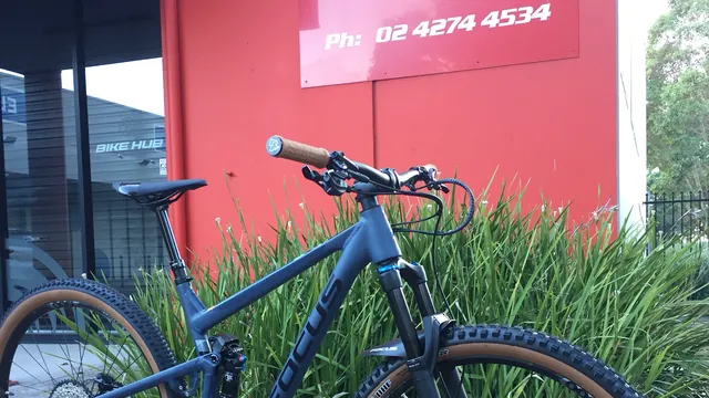 A dark blue mountain bike against the red shopfront