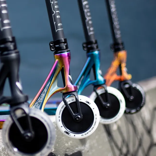 Three pro scooters with rainbow bars and wheels